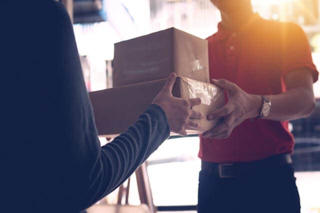 Courier handing parcels to a customer